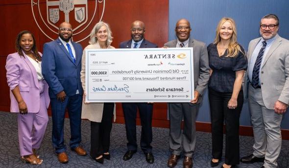 ODU and Sentara 健康care representatives pose with a large bank check for $300,000 made out to the Old Dominion University Foundation.